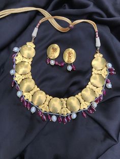 This Antique Necklace is very Beautiful. It is a handcrafted One of a Kind Piece. It is set in 22Kt Gold with Rosecut Diamonds, Ruby, and Pearl. It has Pearl and Ruby Gemstone Beads at bottom of the Necklace and Earring. It is a Perfect Gift for Anniversary, Gift for Mother, Wedding Gift. This Necklace set is a traditional piece Indulge yourself or buy as a gift for a loved one. Details : Gross Weight: 187.590 gms Dimensions : Necklace Length - 11 Inches +Adjustable Dori Center Drop: 43mm (Inclu Elegant Kundan Jewelry Sets In Dual-tone, Elegant Dual-tone Kundan Jewelry Sets, Round Gemstone Temple Necklace For Festive Occasions, Yellow Gold Kundan Necklace With Gemstone, Gold Plated Yellow Gold Kundan Necklace, Hand Set Yellow Gold Plated Kundan Necklace, Hand Set Yellow Gold-plated Kundan Necklace, Elegant Gold Dual-tone Kundan Necklace, Yellow Gold Round Temple Necklace With Meenakari