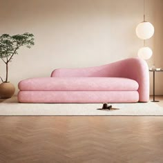 a pink couch sitting on top of a wooden floor next to a potted plant