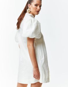 Shift mini in breathable linen with heritage-inspired embroidery. Reinforced mandarin collar with adjustable pearlized button closure. Elasticized puff sleeves. Side seam hand pockets. Modern Barong, Long Slip Dress, Cocktail Attire, Embroidered Linen, Mini Shift Dress, Linen Dresses, White Mini Dress, Mandarin Collar, Model Height