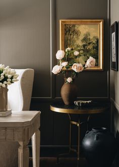 a vase filled with white flowers sitting on top of a table next to a chair