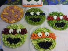 four plates with vegetables and faces made to look like veggies