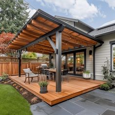 a patio with a table and chairs under a wooden roof