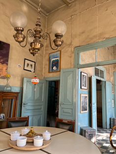 an old fashioned dining room with blue doors and chandelier