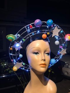 a mannequin wearing a headdress with planets and stars on it's forehead