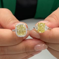 a woman holding two yellow and white diamond engagement rings in her hands, both with diamonds on them