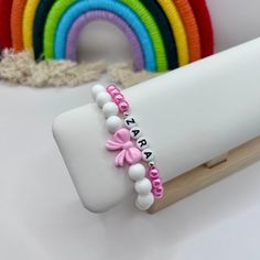 This cute handmade bracelet stack is made with a variety of colourful faux glass pearls, silicone beads, an acrylic bow charm and round acrylic initial beads, with your choice of name or word.  Designed and handmade in Scotland using quality stretch elastic, it's the perfect birthday or Christmas gift for kids, for your best friend or a party bag.  There's a range of colours to choose from and it can be made with either silver or gold plated spacer beads either side of the name / word.  If you'd Pink Name, Pink Names, Bow Charm, Stacking Bracelets, Perfume Making, Pretty Bracelets, Name Bracelet, Elastic Bracelet, Girls Birthday