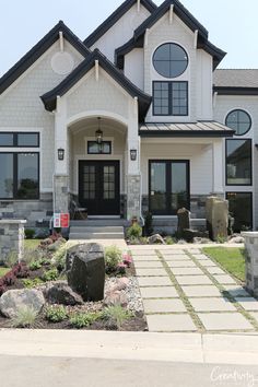 a large white house with lots of windows and stone steps leading to the front door