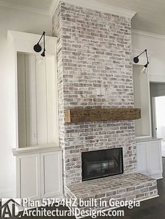 an empty living room with a brick fireplace