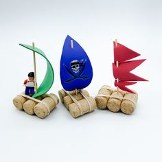 there are three toy sailboats on top of wine corks