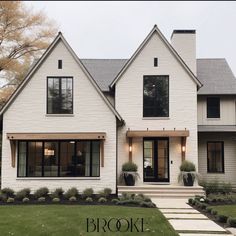 a white house with black windows and steps leading up to the front door that says brooke