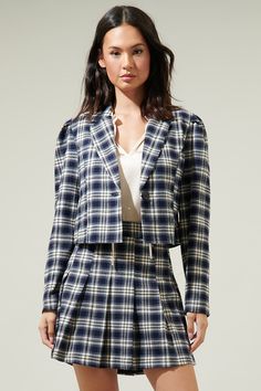 The Hillard Plaid Cropped Blazer is a fashion must-have! Plaid pattern fabric shapes this cute blazer, has a collared neckline and long sleeves with some puff on the shoulders. The cropped bodice has one button in the middle. Pair with the matching Hillard Plaid Mini Skirt for a complete look!- Plaid - Crop blazer- Pleated long sleeves- Lined- Color: Navy IvorySize + Fit - Model is 5'8" and wearing size XS- Measurements taken from size S - Chest: 17 3/4"- Length: 19 1/2" Fabric self: 100%polyest Chic Collared Cotton Blazer, Chic Cotton Collared Blazer, Tailored Cropped Jacket With Long Sleeves For Fall, Cotton Long Sleeve Blazer For Day Out, Trendy Notch Lapel Cropped Jacket For Fall, Trendy Cropped Jacket With Notch Lapel For Fall, Trendy Fitted Collared Blazer, Fall Cotton Blazer For Day Out, Preppy Single-breasted Long Sleeve Blazer