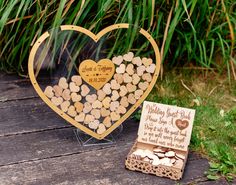 a wooden heart shaped box filled with small hearts next to a card board that says wedding guest book