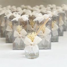 there are many small glass bottles with flowers in them and tied together to each other