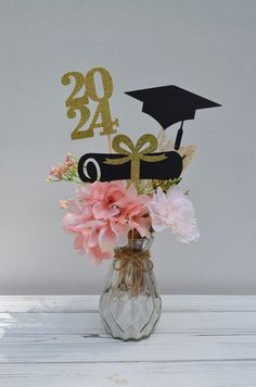 a vase filled with flowers sitting on top of a white wooden table next to a sign