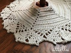 a crocheted doily is on the floor next to a coffee mug holder