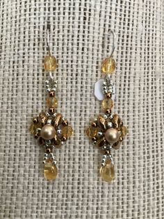 These are very small - almost tiny earrings... done with bronze super duos , vintage Swarovski matte gold pearls , amber color Czech crystal beads and drop beads and Silver and bronze galvanized seed beads ... that's a lot of beads woven into such a tiny earring  With Sterling Silver ear wires with an amber bead on them and rubber ear nuts ... measuring 1 2/3 inches on the ear ... these earrings are tiny , delicate , and dramatic, all at the same time ... and oh so feminine  Just a beautiful ear Tiny Earring, Tiny Earrings, Amber Beads, Czech Crystal, Drop Beads, Amber Color, Gold Pearl, Matte Gold, Ear Wires