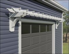 a gray garage with a white trellis on the side