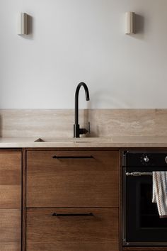 a kitchen with wooden cabinets and an oven in the center, along with two lights on either side of the sink