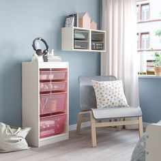 a room with blue walls and white furniture in it, including a chair and bookshelf