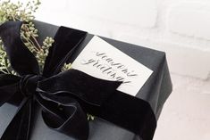 a gift wrapped in black velvet with a ribbon