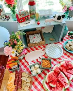 a table filled with watermelon slices, crackers and other food on it