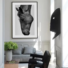 a black and white photo of a horse's head hangs in the living room