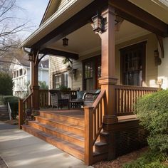 a porch with wooden steps leading up to the front door and covered in wood furniture