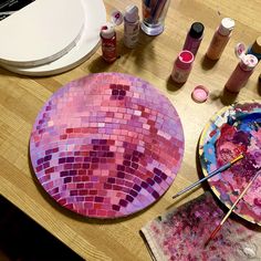 a table topped with lots of crafting supplies on top of a wooden table next to a plate