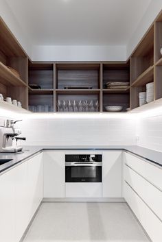 an empty kitchen with white cabinets and counter tops