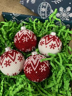 three red and white ornaments sitting in green grass