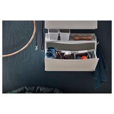 a white shelf with two bins filled with various items next to a shower hose