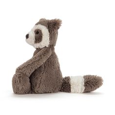 a stuffed racoon is sitting on the floor with its arms folded up and eyes closed