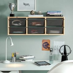 a white desk topped with drawers next to a wall mounted phone and bookshelf