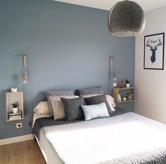 a bed room with a neatly made bed and blue walls