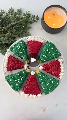 a cake decorated with red, green and white icing next to a cup of orange juice