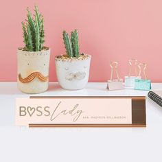 three potted plants sitting on top of a desk next to a sign that says boss lady