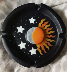 a black tray with white stars and a sun painted on it