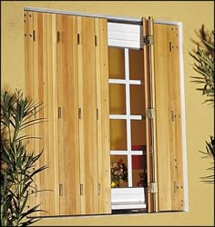 an open window with wooden shutters and potted plants