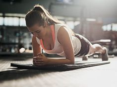 a woman is doing push ups on a mat