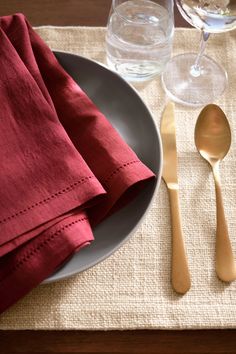 a place setting with utensils and napkins on a tableclothed place mat