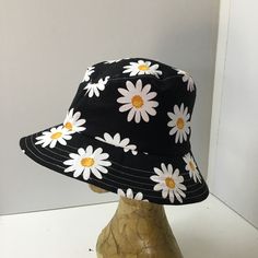 Womens bucket hat or sunhat is a fresh looking black hat with a white daisy design.  The hat will fit average sized heads, and has an inside elastic cord for adjusting.  It is lined.  The brim is topstitched, and can be worn up at the front or back, or all around for a different look.  A great casual hat  that can be folded or rolled to keep in your bag.  Please check your head measurements. Measurements  Inside60cms.     23 1/2" Brim6.5cms.      2 1/2" Bucket Hat Painting Ideas, Bucket Hat Painting, Cotton Bucket Hat, Bucket Hat White, Black Bucket Hat, Daisy Design, Flower Hats, White Daisy, Casual Hat