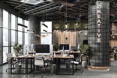 an office with large windows and lots of desks in the center, surrounded by plants