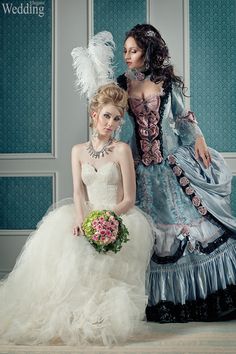 two women in wedding dresses standing next to each other, one wearing a dress with feathers on it