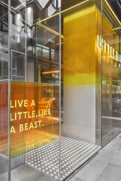 an image of a glass display case with words on the front and back sides that say live a little, like a beast