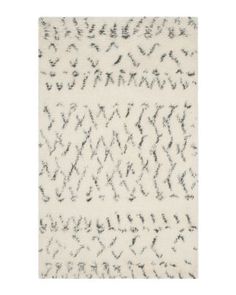 a white rug with black and grey designs on the bottom, it is very soft