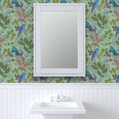 a white sink sitting under a bathroom mirror next to a wall mounted faucet