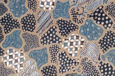 a blue and black patterned fabric with white flowers on it's side, in the middle