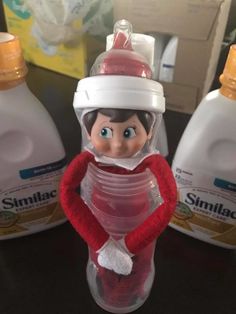 the elf is sitting in front of two bottles of mouthwash and toothpaste