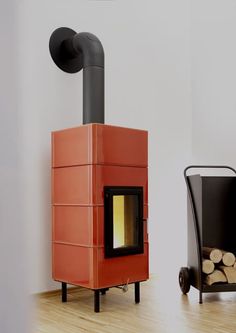 an orange stove sitting next to a pile of logs on top of a hard wood floor