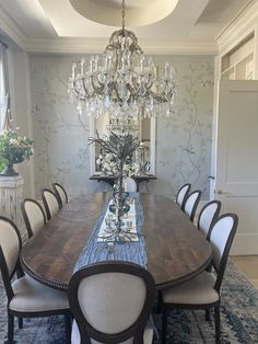 a dining room table with chairs and a chandelier